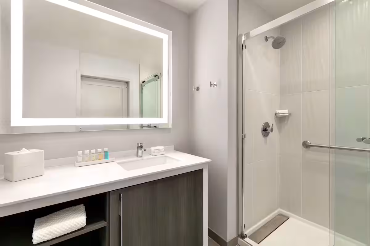 modern and bright bathroom with lighted mirror and glass shower